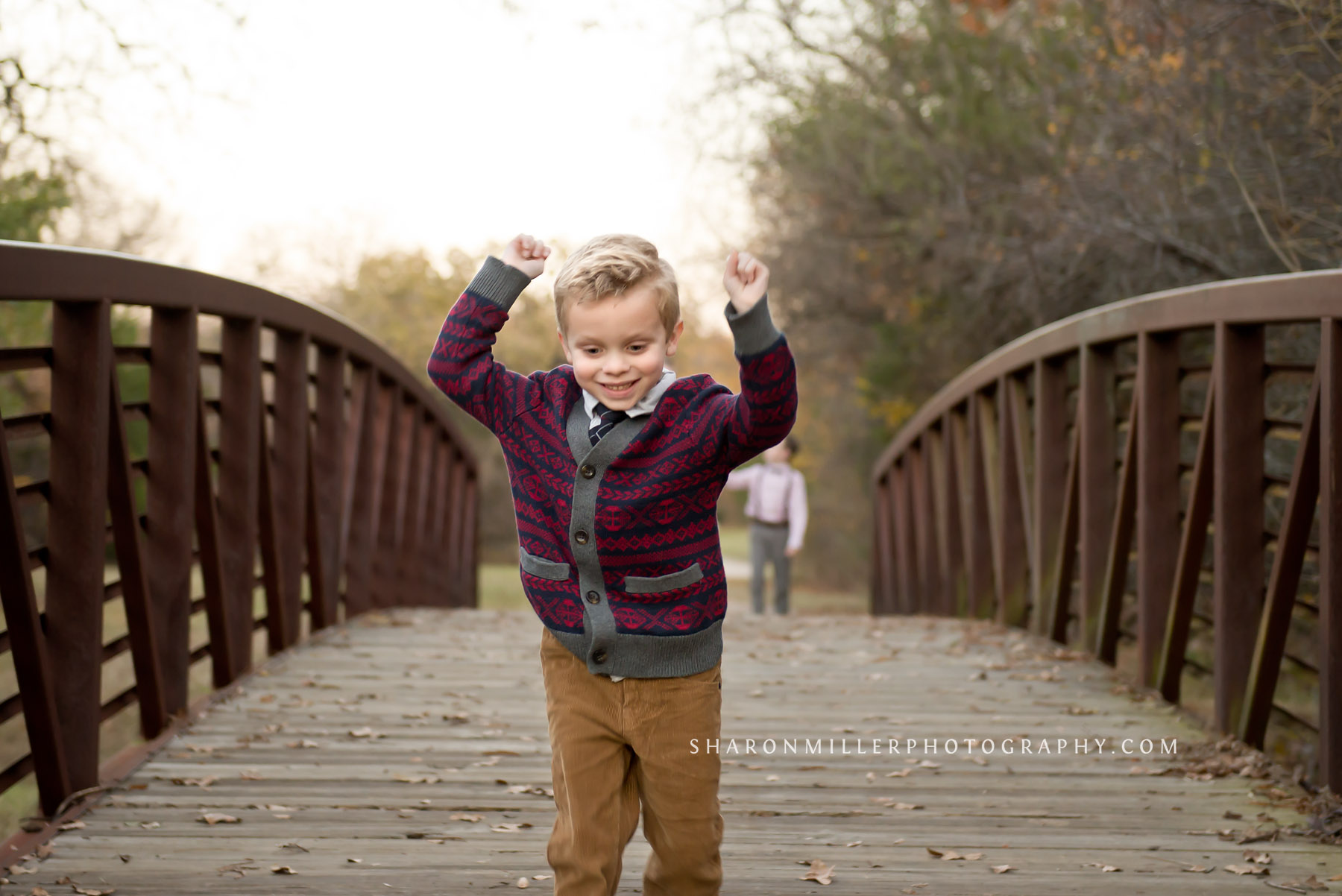 cute boy in cardigan running gleefully